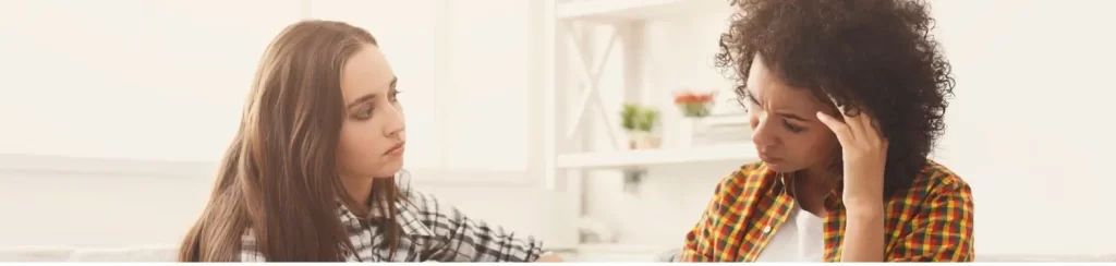 A concerned woman listening and supporting her friend during rehab conversation