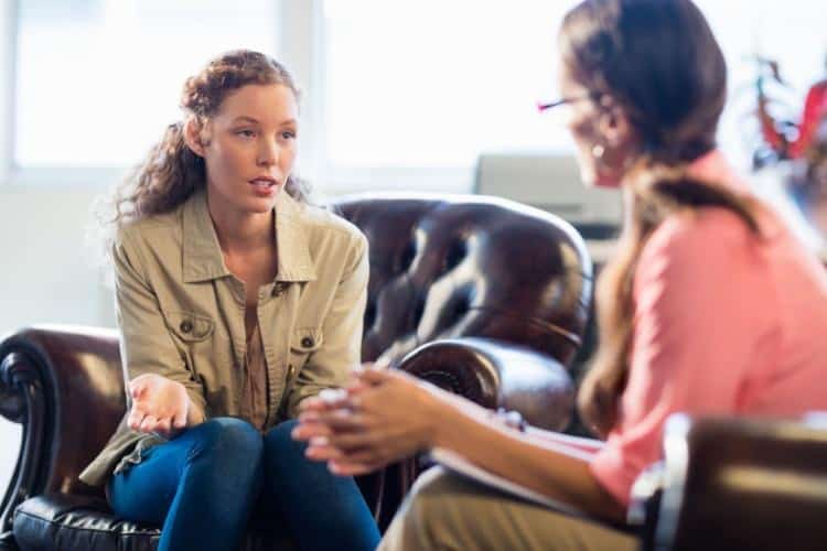 Addiction Specialist Young woman talks to therapist about how she wants to wean off alcohol