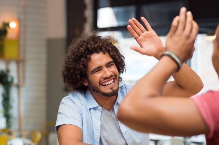 Celebrate Yourself Happy man high fives friend to celebrate his sobriety