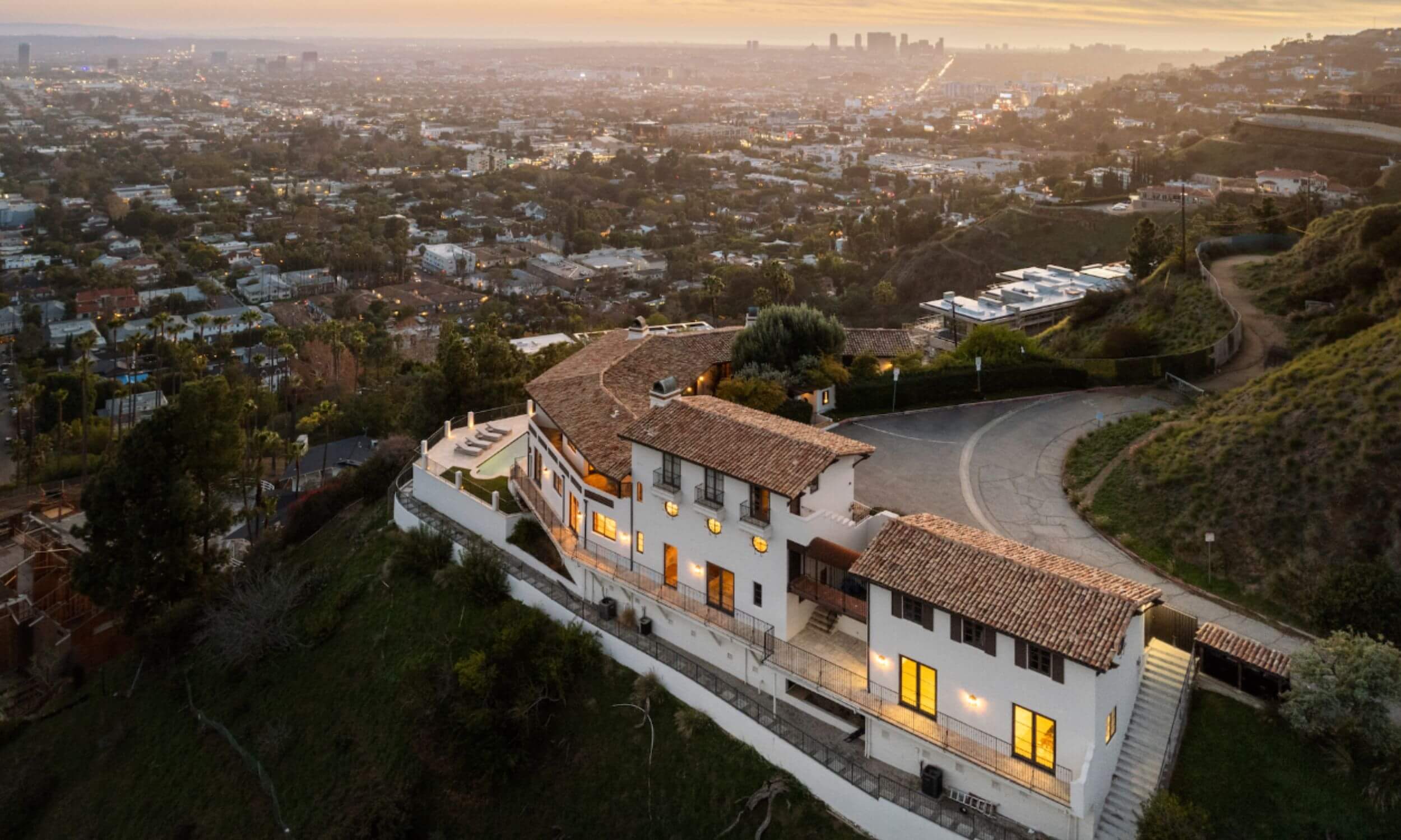 The image depicts a serene sunrise over a tranquil view of Los Angeles, with gentle mist rising from the city, creating a peaceful atmosphere. This scene symbolizes the hope and new beginnings often associated with the recovery journey from substance abuse and addiction treatment with the aerial view point of one of Legacy's luxury rehabs in California.