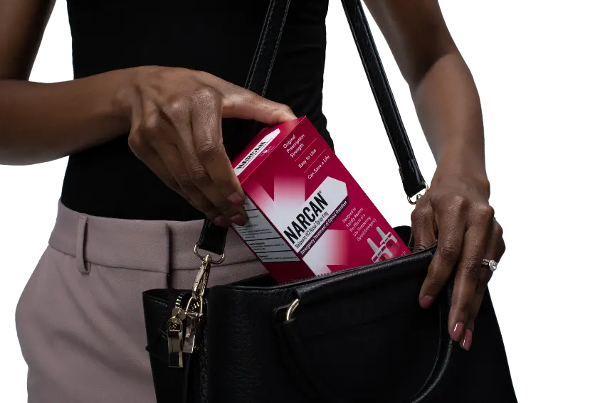 Person putting Narcan nasal spray into a bag for fentanyl overdose prevention and emergency opioid reversal